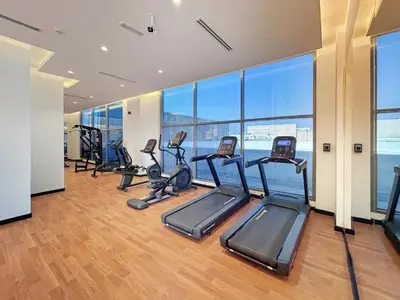 a gym with treadmills and ellipticals in a building at Elegant 1BR with Pool Gym & Burj Khalifa Views in Dubai
