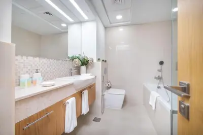 a white bathroom with a sink and a toilet at Vogue Downtown Bellevue Towers near Burj Khalifa and Dubai Mall, One bedroom Apartment with Balcony and City view, Access to all Amenities in Dubai