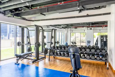 a gym with treadmills and weights at Vogue Downtown Bellevue Towers near Burj Khalifa and Dubai Mall, One bedroom Apartment with Balcony and City view, Access to all Amenities in Dubai