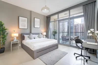 a bedroom with a bed and a desk and a window at Vogue Downtown Bellevue Towers near Burj Khalifa and Dubai Mall, One bedroom Apartment with Balcony and City view, Access to all Amenities in Dubai