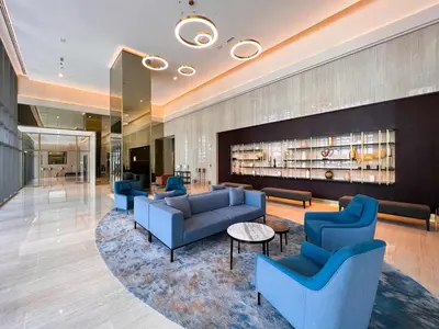a lobby of a hotel with blue couches and tables at Vogue Downtown Bellevue Towers near Burj Khalifa and Dubai Mall, One bedroom Apartment with Balcony and City view, Access to all Amenities in Dubai
