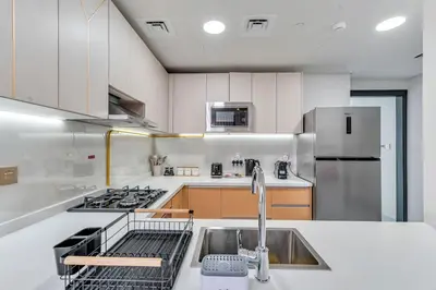 a kitchen with a sink and a stove and refrigerator at Skyz by Danube Chic 2BR with Balcony & Pool Access in Dubai