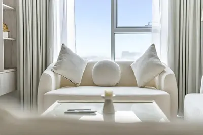a living room with a white couch and a window at Skyz by Danube Chic 2BR with Balcony & Pool Access in Dubai