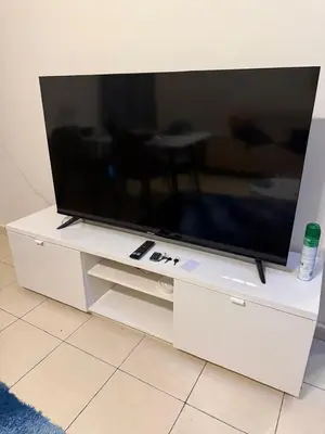 a large flat screen tv on a white entertainment center at Modern 1BR in JVC, 2 Baths, Pool & Gym, Fully Equipped Kitchen in Dubai
