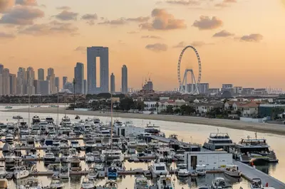 a group of boats in a harbor with a ferris wheel at Amazing Studio with Balcony & Marina Eye Views in Dubai