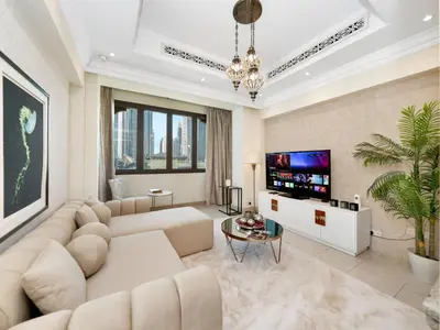 a living room with a couch and a tv at Skyline Select 1 Bedroom Apartment I Burj Khalifa View I Souk Al Bahar Downtown I Parking, Gym, Wi-Fi & Pool in Dubai