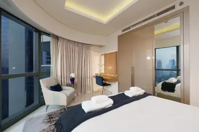 a bedroom with a large white bed with a window at HSHOME - Luxury 3 Bedroom Apartment with Burj Khalifa & Stunning Skyline View in Dubai
