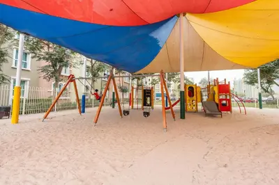 a playground with a swing set in the sand at StayShort - Chic Discovery Gardens 1Bed that Sleeps 2 in Dubai