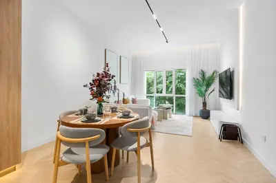 a dining room and living room with a table and chairs at StayShort - Chic Discovery Gardens 1Bed that Sleeps 2 in Dubai
