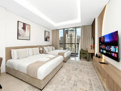 a hotel room with two beds and a flat screen tv at Large modern STUDIO in STERLING DOWNTOWN I DUBAI MALL I Sleeps 4 I Amazing Balcony in Dubai
