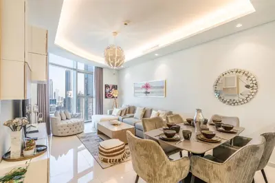 a living room with a table and chairs and a couch at RH - Luxury 2BR at Paramount Midtown, Burj Khalifa View in Dubai