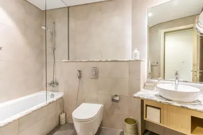 a bathroom with a sink and a toilet and a tub at RH - Luxury 2BR at Paramount Midtown, Burj Khalifa View in Dubai