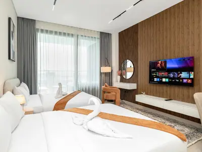 a hotel room with two beds and a flat screen tv at Luxury Studio with Private Jacuzzi & Balcony Trillionaire Residences 4 Guests in Dubai