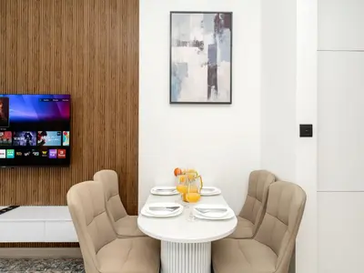 a dining room with a white table and chairs at Luxury Studio with Private Jacuzzi & Balcony Trillionaire Residences 4 Guests in Dubai
