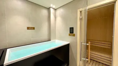 a bathroom with a bath tub next to a shower at Luxury Studio with Private Jacuzzi & Balcony Trillionaire Residences 4 Guests in Dubai