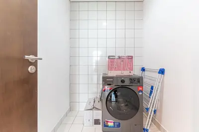 a washing machine in a corner of a room at HAVN - 2 bed in Hilliana Tower, Jumeirah Burj View in Dubai