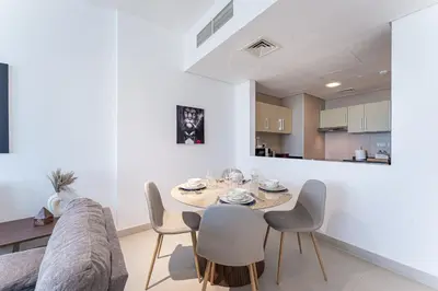 a dining room and kitchen with a table and chairs at HAVN - 2 bed in Hilliana Tower, Jumeirah Burj View in Dubai