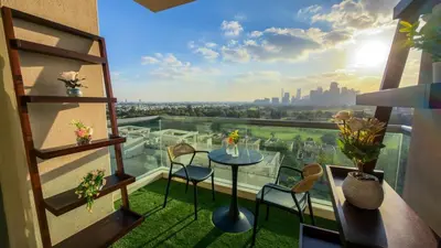 a balcony with a table and chairs and a view of the city at Luxury 2BR Haven with Panoramic Scenery - The Greens in Dubai