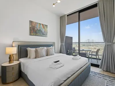 a bedroom with a bed and a balcony with a table at Charming 2BDR Stay in Binghatti Corner- JVC in Dubai