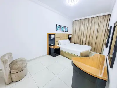 a hotel room with a bed and a chair at DAMAC CAPITAL BAY - Blueocean Holiday Homes in Dubai