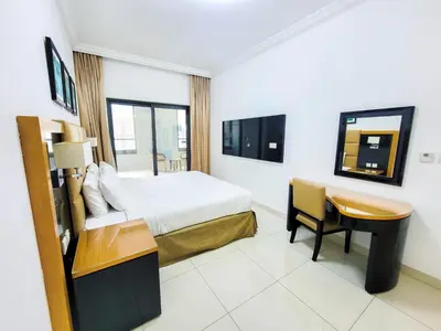 a hotel room with a bed and a desk at DAMAC CAPITAL BAY - Blueocean Holiday Homes in Dubai