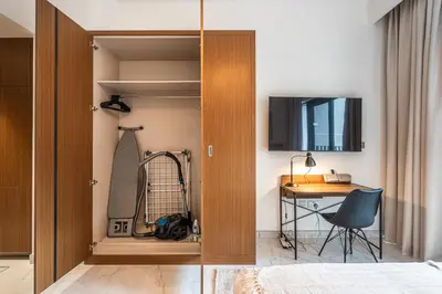 a bedroom with a closet with a desk and a chair at Exquisite studio apartment in Azizi Mirage in Dubai
