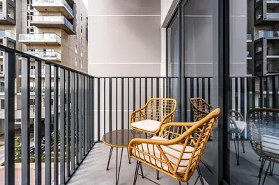 a balcony with two chairs and a table at Exquisite studio apartment in Azizi Mirage in Dubai