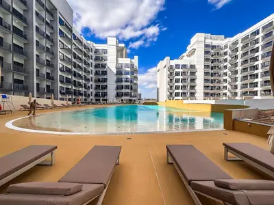 a swimming pool in the middle of two apartment buildings at Exquisite studio apartment in Azizi Mirage in Dubai