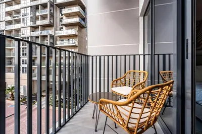a balcony with two chairs and a table at Exquisite studio apartment in Azizi Mirage in Dubai