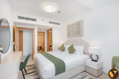 a white bedroom with a bed and a mirror at Vogue JLT Global Lake View Tower near Marina and JBR, Two Bedroom Apartment with Balcony and City view, Access to all Amenities in Dubai
