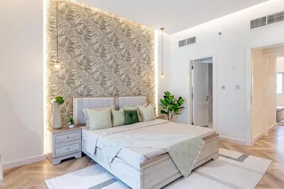 a bedroom with a large bed with a wall at HAVN- 3 bedroom in DAMAC Majestine, Business Bay in Dubai