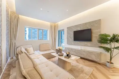 a living room with a couch and a tv at HAVN- 3 bedroom in DAMAC Majestine, Business Bay in Dubai