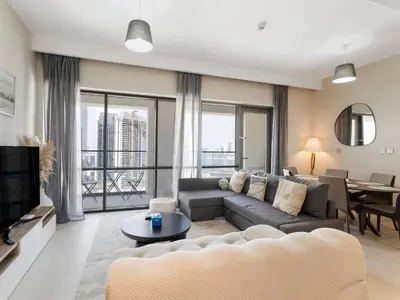 a living room with a couch and a tv at Opulent Haven 2BDR w Sofa Bed Sleeps 6 In Vida-02 in Dubai