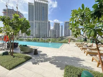 a swimming pool with lounge chairs and a city skyline at Opulent Haven 2BDR w Sofa Bed Sleeps 6 In Vida-02 in Dubai