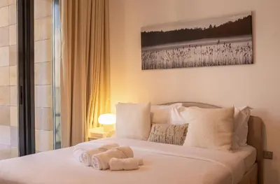 a bedroom with a bed with towels on it at Large Beautiful One Bed Downtown Dubai in Dubai