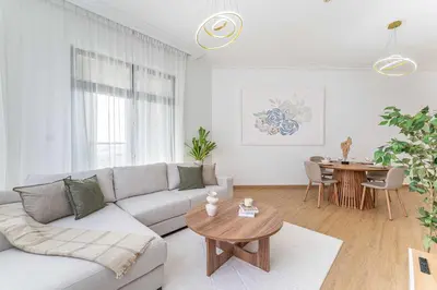 a white living room with a couch and a table at HAVN- High floor 1 bedroom in Business Bay in Dubai