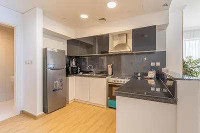 a kitchen with a stainless steel refrigerator and counters at HAVN- High floor 1 bedroom in Business Bay in Dubai