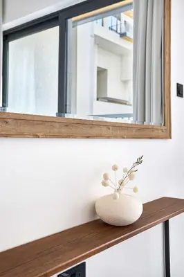 a vase sitting on a wooden shelf under a window at Frank Porter - The Crest Tower, Sobha Hartland in Dubai
