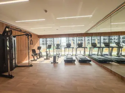 a gym with a row of treadmills and a large window at Frank Porter - Azizi Beach Oasis in Dubai