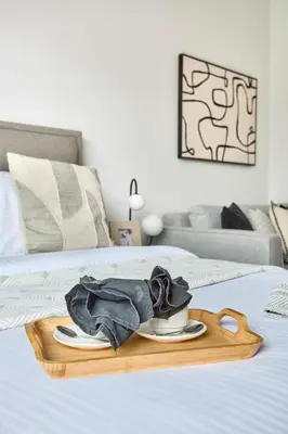 a tray with a cup of coffee on a bed at Frank Porter - Azizi Beach Oasis in Dubai