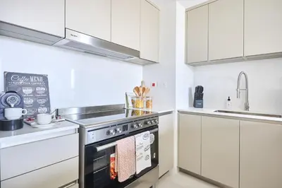 a kitchen with white cabinets and an oven at Frank Porter - Al Jazi in Dubai