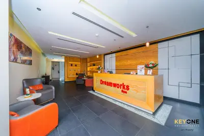 an office with a waiting area with orange chairs and a warlords counter at The Cosmopolitan Spacious Studio in Dubai