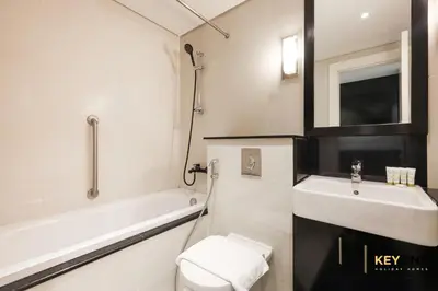 a bathroom with a sink and a toilet and a bath tub at The Cosmopolitan Spacious Studio in Dubai