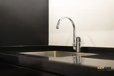 a kitchen sink with a faucet on a counter at The Cosmopolitan Spacious Studio in Dubai