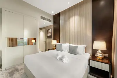 a bedroom with a large white bed with two towels on it at FIRST CLASS 2BR Vibrant Next to Dubai Mall in Dubai