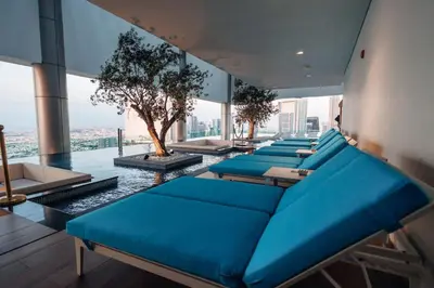 a room with blue couches and a tree on the floor at Paramount 10 Min to Dubai Mall, Luxury Amenities in Dubai