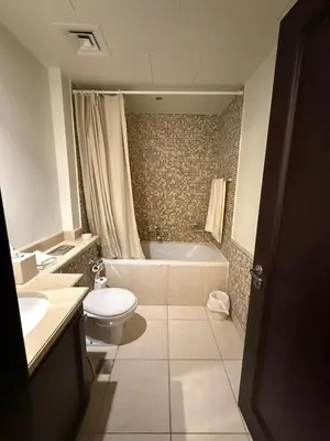 a bathroom with a toilet and a tub and a sink at Burj Khalifa 2 BR apartment in the down town in Dubai