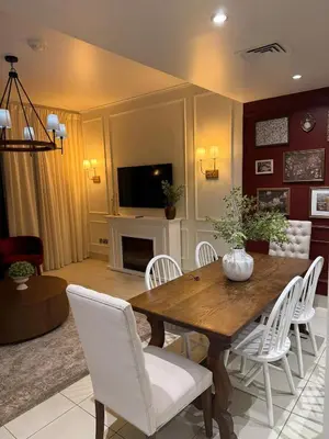 a living room with a wooden table and white chairs at Burj Khalifa 2 BR apartment in the down town in Dubai