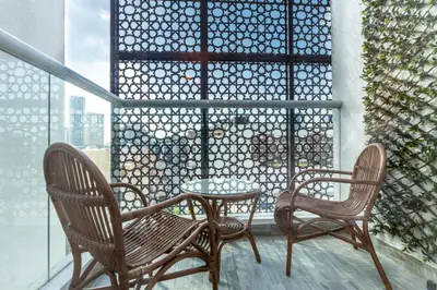 a patio with two chairs and a table on a balcony at Stylish Studio in JVC with Pool and Gym Access in Dubai