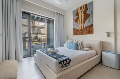 a bedroom with a bed and a large window at GuestReady | New 1BR with Maid’s Room | Spacious in Dubai